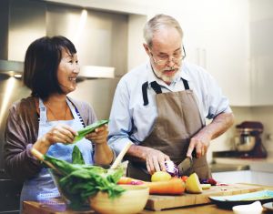 A couple cooks dinner at home.