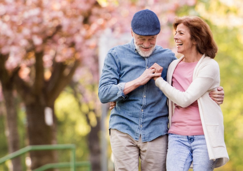 A man and woman walk through spring blossoms.