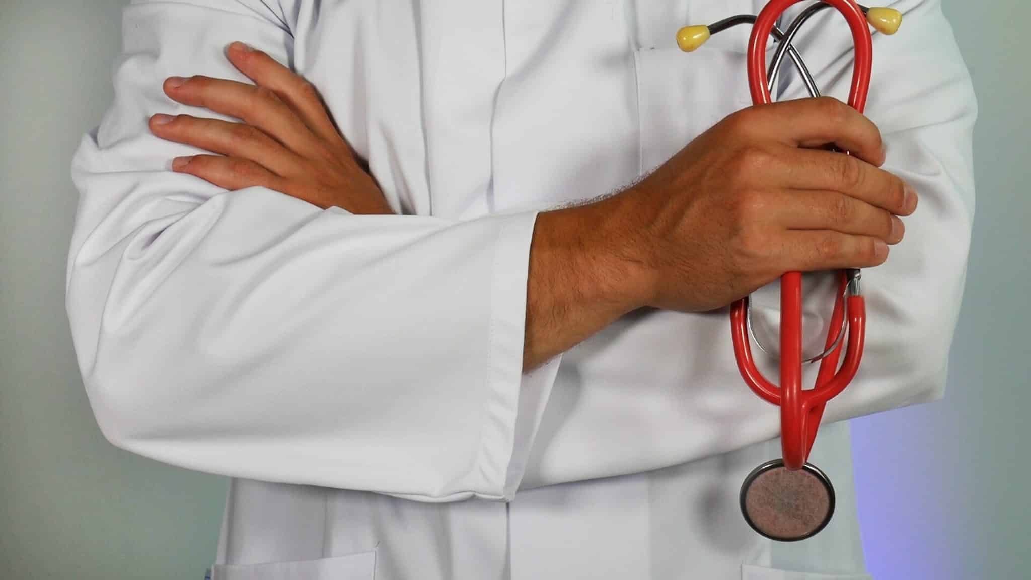 doctor holds stethoscope in lab coat