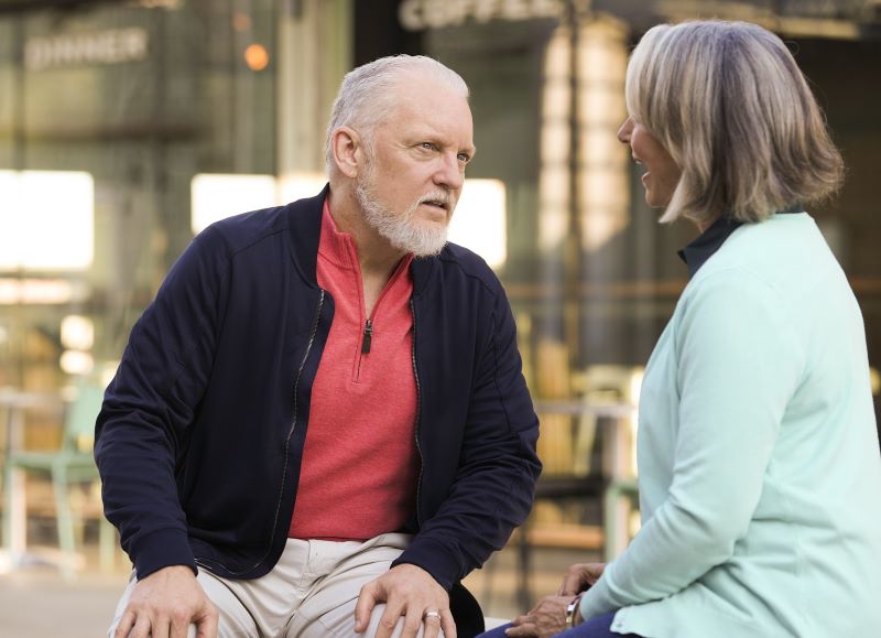 A man struggles to hear a conversation at a cafe.