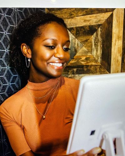 A woman wears DeafMetal jewelry on her hearing aid.