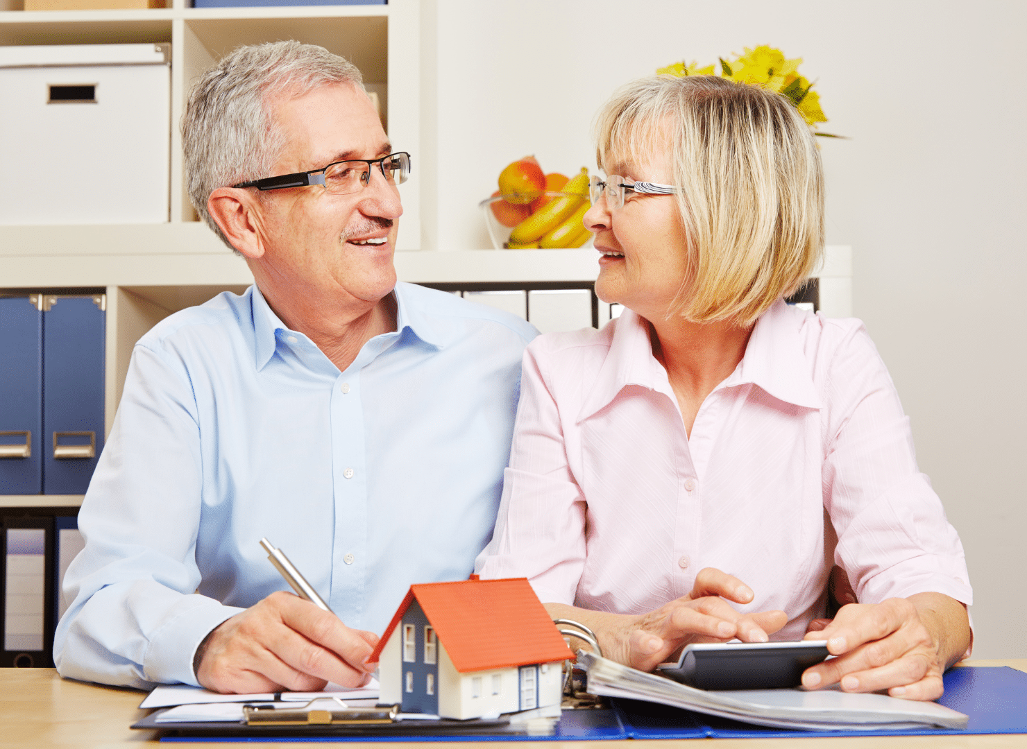 older couple with pen and calculator preparing finances