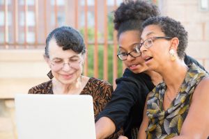 A mother, daughter and grandmother gather together.