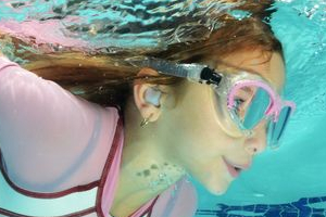  A girl swims with ear plugs.