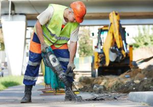 A construction worker uses a jackhammer.