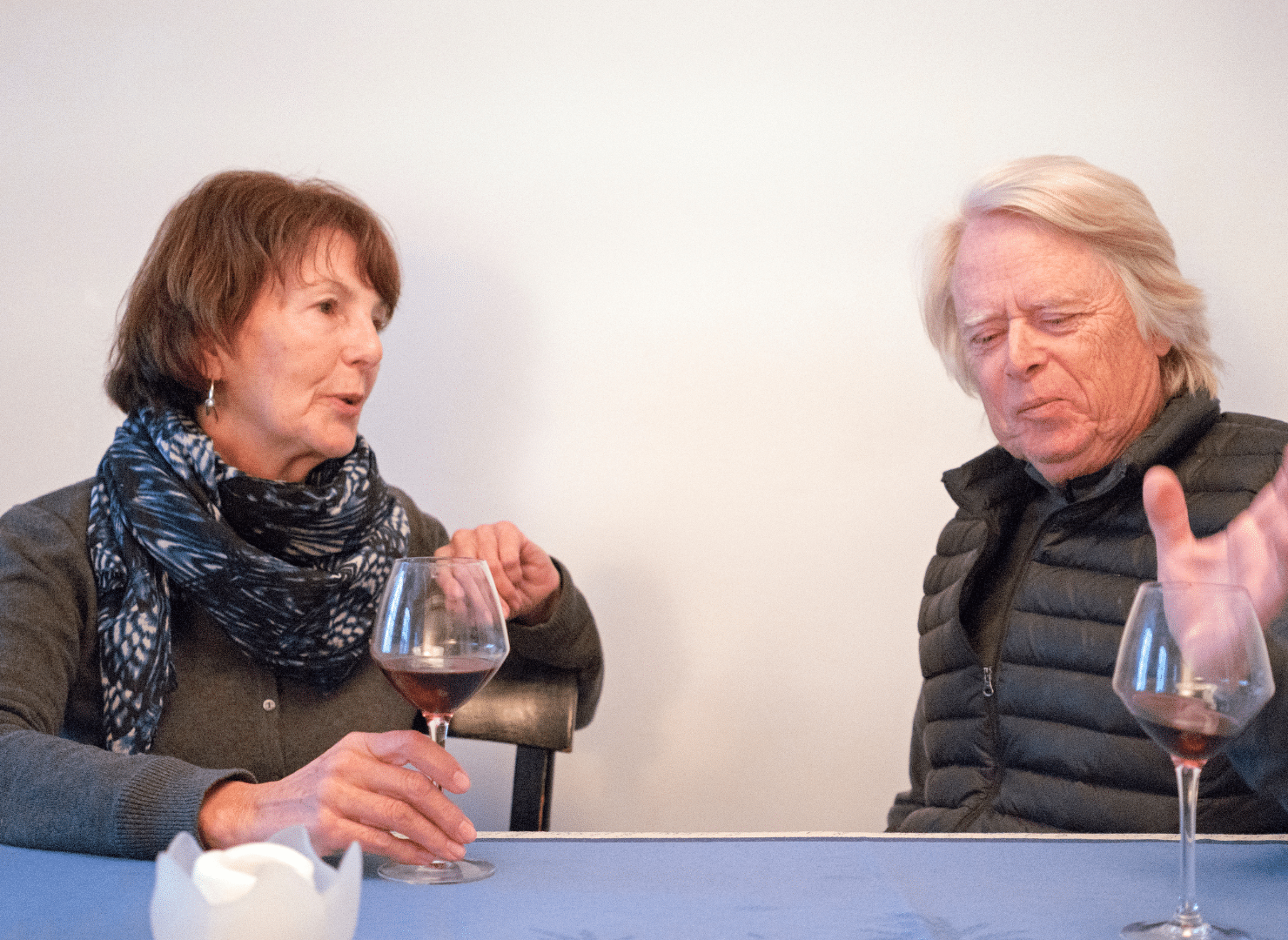 couple sitting at table having trouble hearing words in conversation 