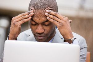 A man grips his head in frustration with tinnitus.
