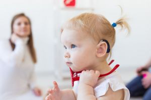 A baby girl with a hearing aid.