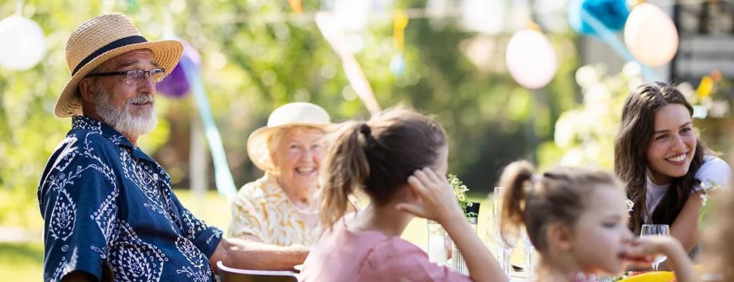 Image of extended family sitting at picnic table outdoors
