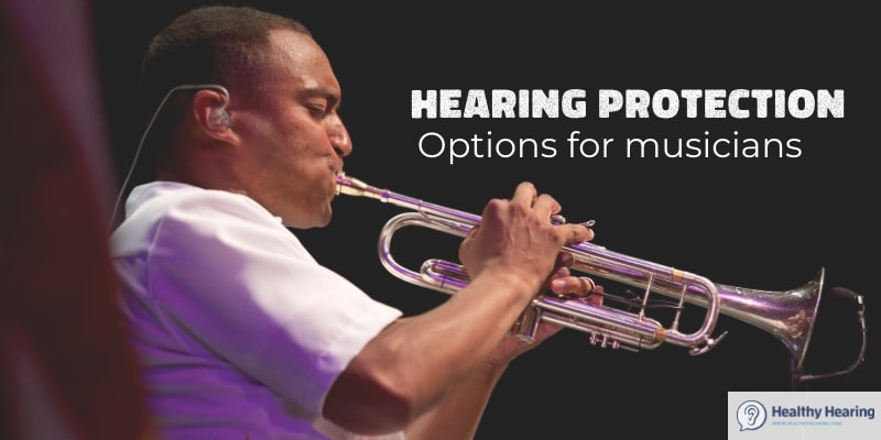 A musician plays a trumpet with an in-ear monitor.